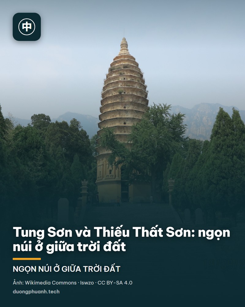 Dãy Thiếu Thất Sơn nhìn từ thành phố Đăng Phong: khối núi đá vôi xanh xám dựng thành một bức tường dài phía trên mái nhà và các rặng cây của thị trấn, phía trên là tầng mây tối với những tia nắng xuyên chéo xuống sườn núi và vùng đồng bằng phía trước.