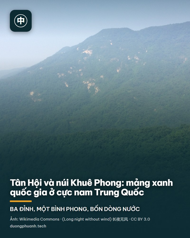 Chính điện chùa Ngọc Đài trên núi Khuê Phong, Tân Hội: tòa nhà mái ngói vàng cong, hàng cột đỏ, dây cờ ngũ sắc giăng ngang trước sân, phía sau là sườn núi phủ rừng xanh và vạt trời xanh có mây.
