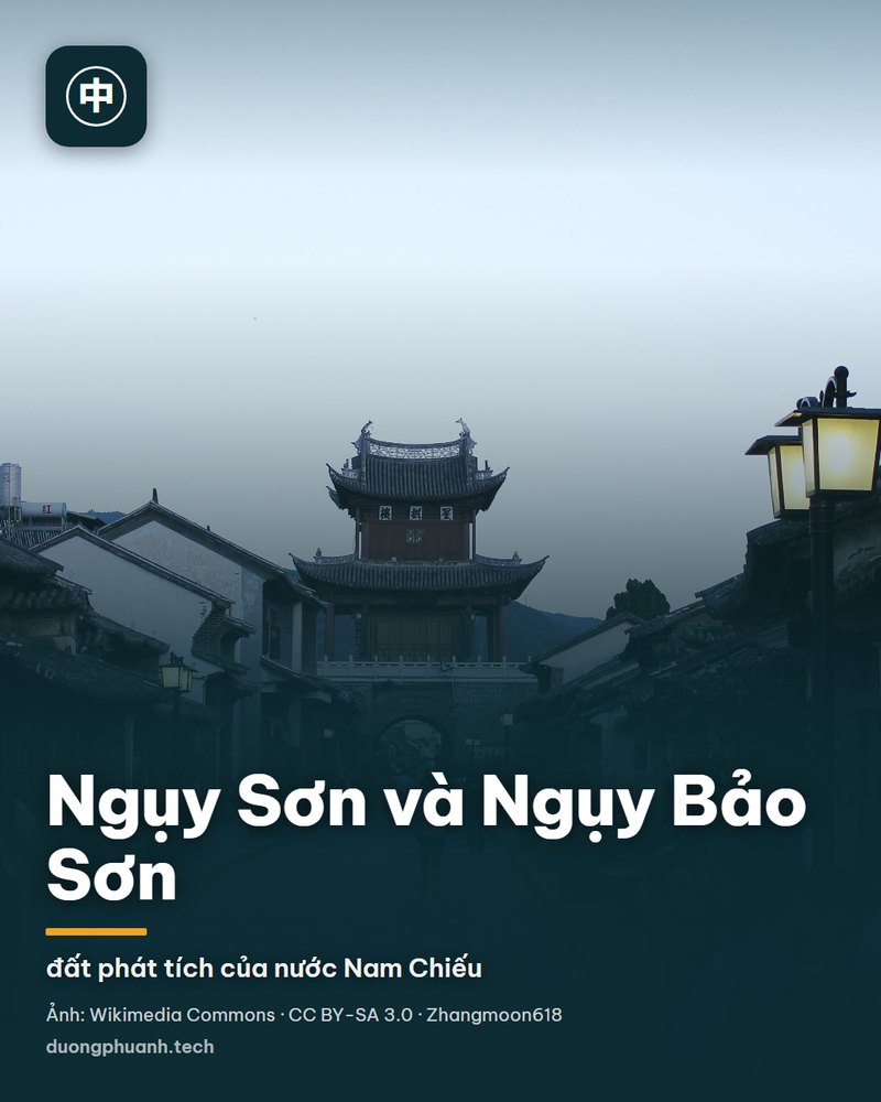 Cổng chào bằng đá của khu phố cổ Ngụy Sơn, Vân Nam: cổng xây thẳng và vuông vức, hai bên là dãy nhà gỗ mái ngói cổ, nắng chiều vàng trải trên con đường đá lát, có người đi bộ và xe máy dựng ven đường.