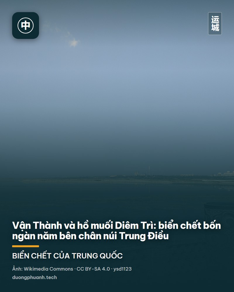 Hồ muối Vận Thành nhìn từ một lối đi có lan can đá: mặt nước phẳng lặng màu xanh xám trải rộng tới chân dãy núi Trung Điều mờ xanh phía xa, hai trụ đá chạm hoa văn mây nổi bật ở tiền cảnh, trời trong veo có vài đám mây trắng nhỏ