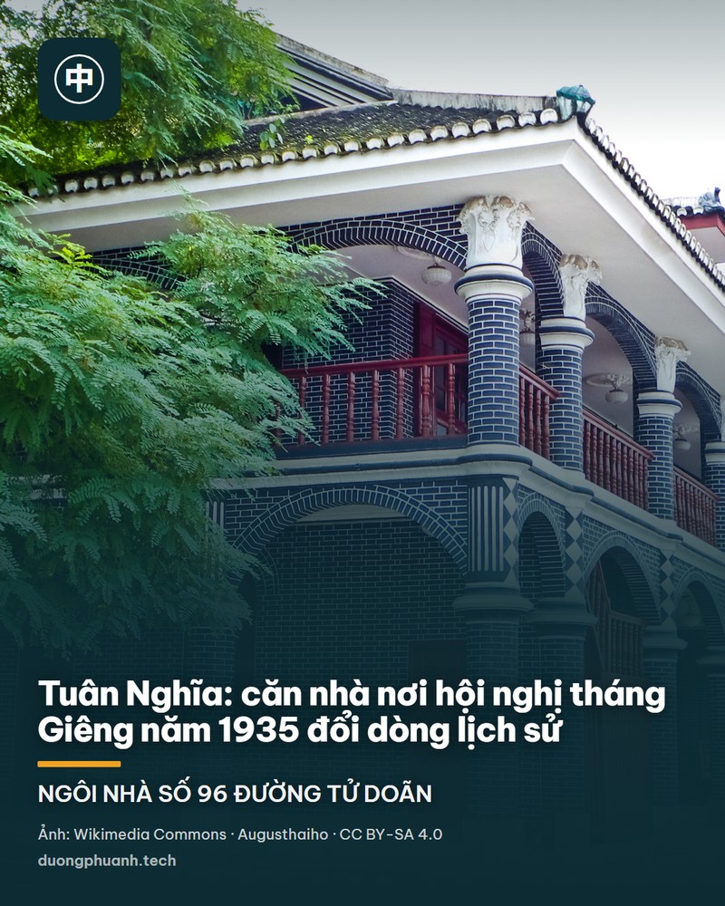 Sân trong của di tích hội nghị Tuân Nghĩa: toà nhà hai tầng xây gạch xám có hàng hiên vòm cuốn và lan can gỗ sơn đỏ, trên sân đông du khách mặc đồng phục xám, đội mũ gắn ngôi sao đỏ, đang chụp ảnh trước cửa gỗ lớn của toà nhà.