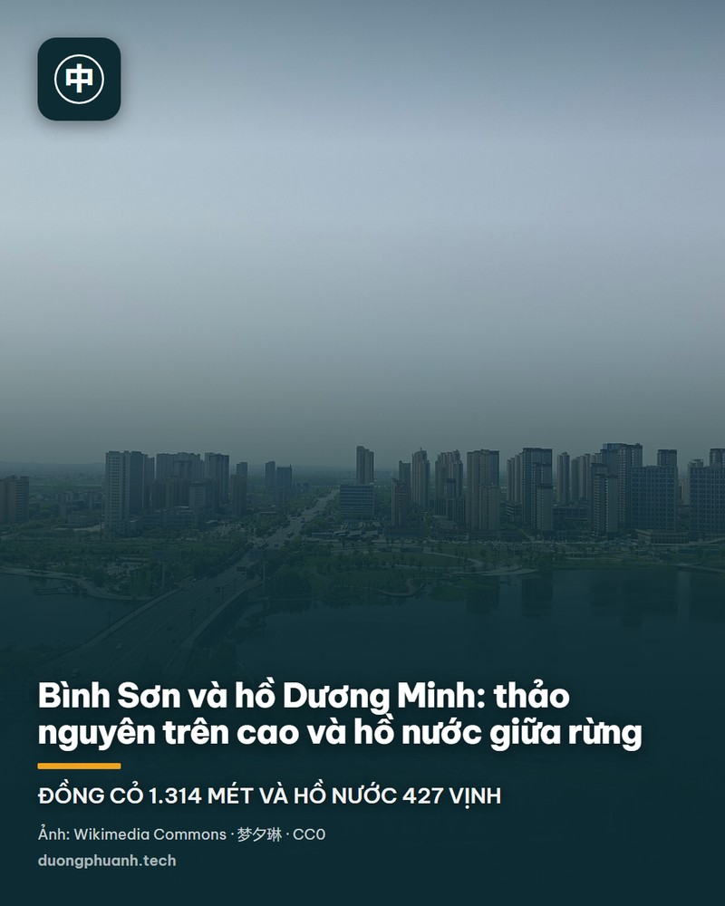 Mặt hồ Dương Minh nhìn từ bờ: nước hồ êm màu xanh xám trải rộng tới chân những ngọn đồi phủ rừng xanh thẫm, phía bên phải có cầu tàu gỗ lợp mái và vài chiếc thuyền nhỏ neo đậu bên bờ.