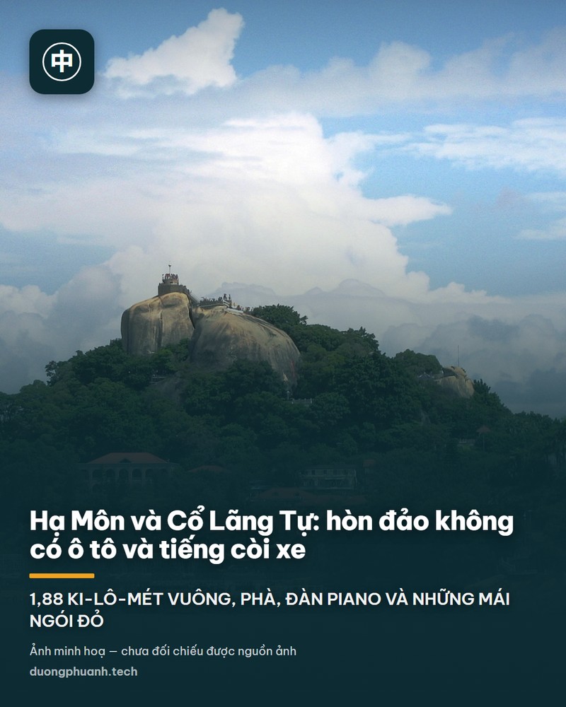 Toàn cảnh Cổ Lãng Tự lúc hoàng hôn nhìn từ Hạ Môn: vòm trời chuyển từ tím sang cam, hòn đảo với hệ đèn ven eo biển, hai bên khung hình là các toà nhà cao tầng của thành phố Hạ Môn
