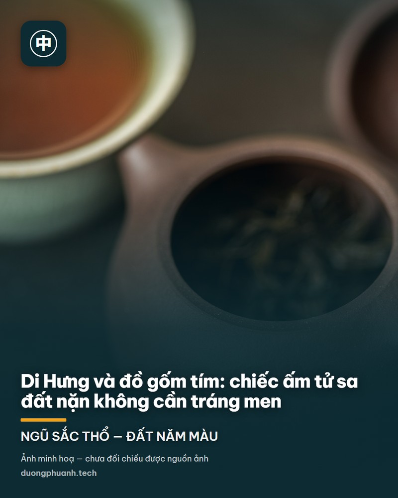 Cận cảnh một ấm trà tử sa màu nâu tím đang mở nắp, bên trong đầy lá trà khô; phía sau là nắp ấm úp nghiêng và một chén nhỏ men xanh nhạt đựng nước trà nâu sẫm; tất cả đặt trên mặt bàn tối, ánh sáng dịu, nền mờ
