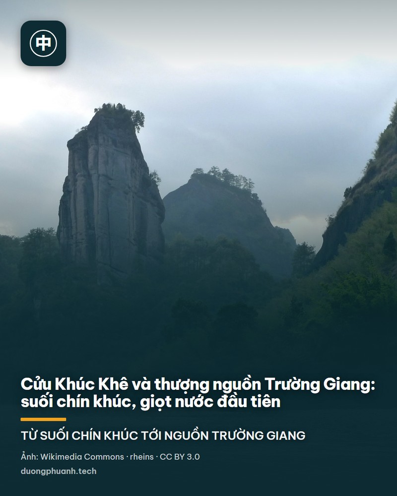 Dòng suối nước xanh phẳng lặng uốn quanh những vách đá đỏ sẫm có vết cắt dọc thẳng đứng ở Vũ Di Sơn, phía xa là rừng xanh phủ kín đỉnh núi, dưới chân vách có vài chiếc bè tre chở khách đang đợi ở bờ.