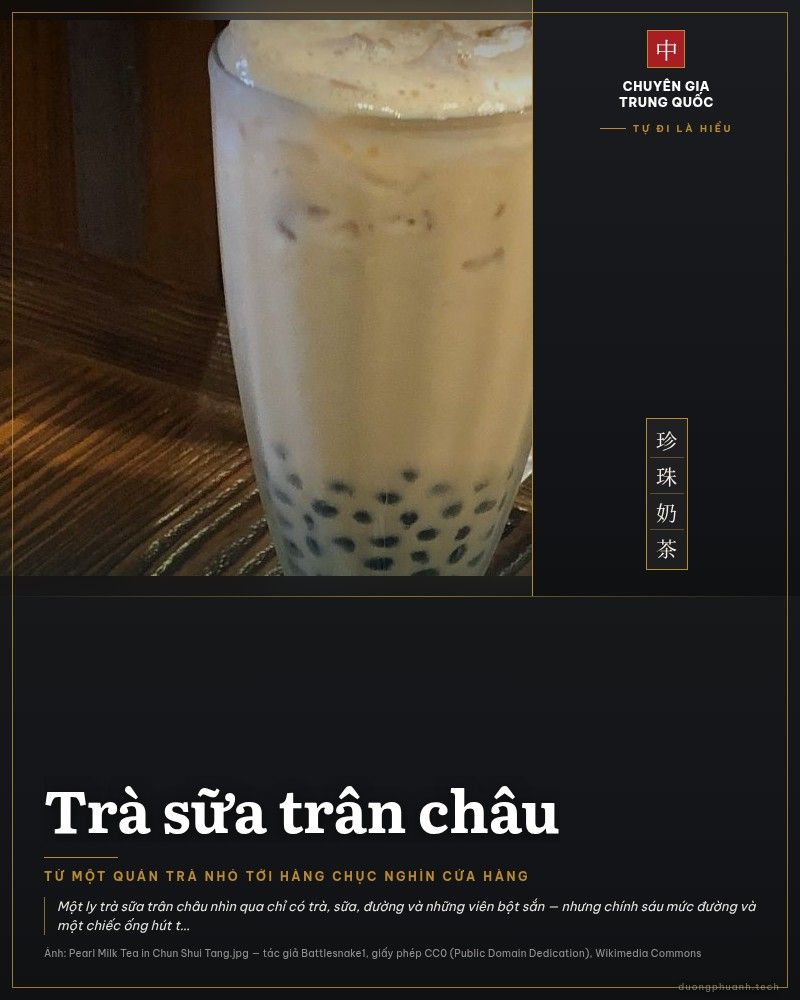 Ly trà sữa trân châu đá trong ly thuỷ tinh đặt trên bàn gỗ, những viên trân châu đen chìm dưới đáy ly