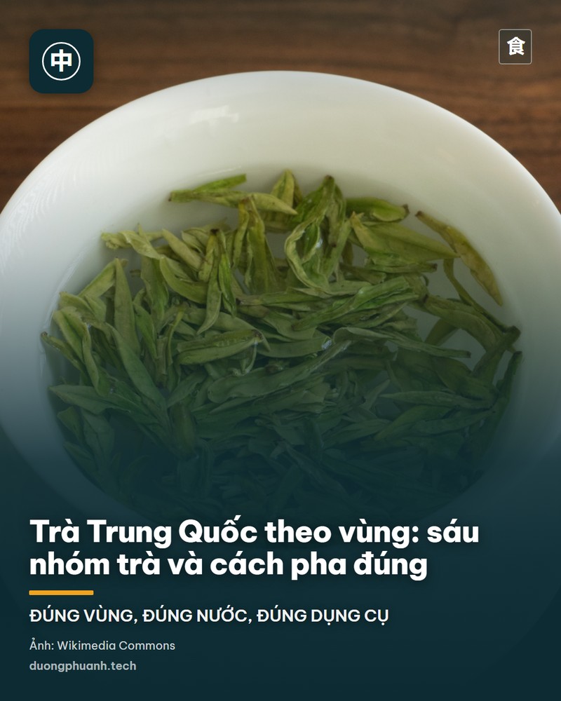 Chén sứ trắng có nắp đựng trà Long Tĩnh xanh mướt đang ngâm nước, đặt trên đĩa sứ cùng màu, nền là mặt bàn gỗ nâu tối