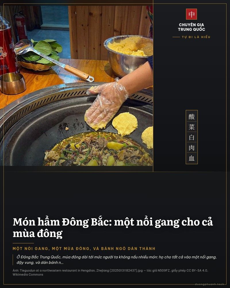 Bàn gỗ có chiếc nồi gang lớn trong lòng bàn, bên trong là món hầm sôi với thịt, khoai tây và rau; một bàn tay đeo bao nilon đang dán miếng bột ngô lên thành nồi, cạnh đó là tô bột bắp và phích nước