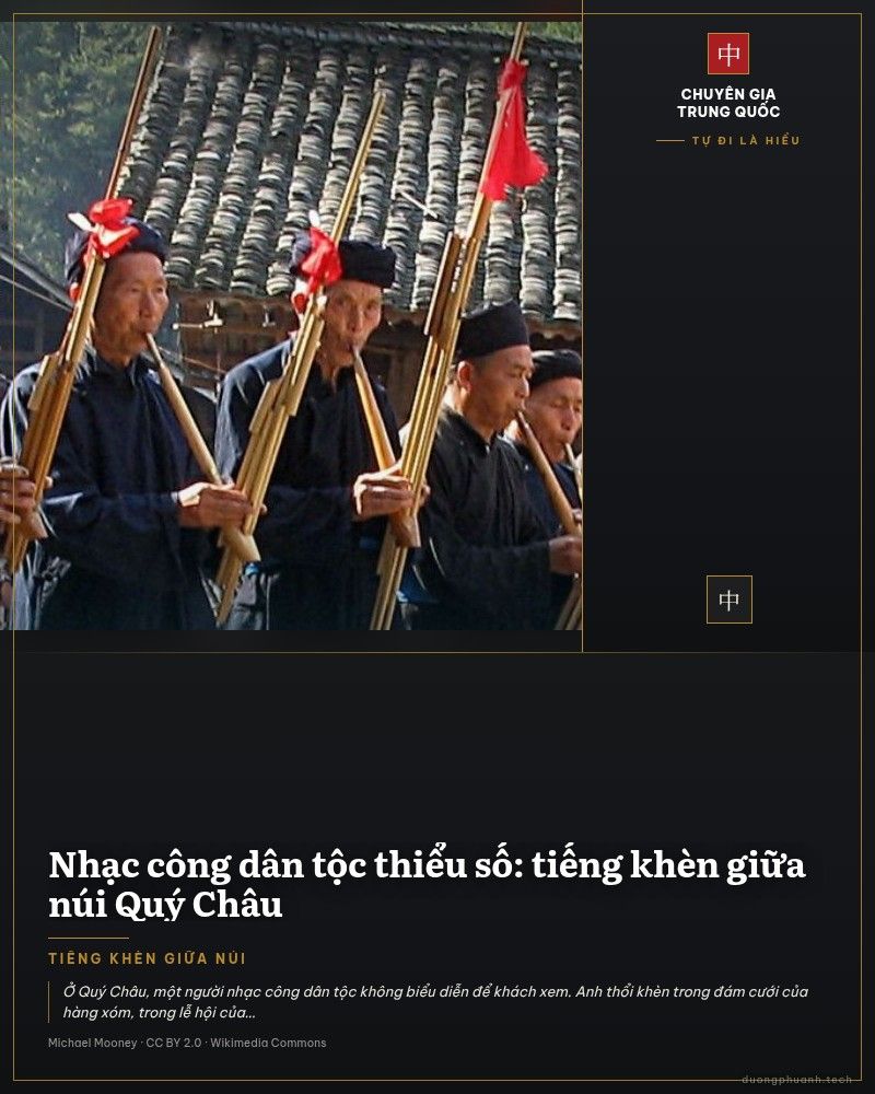 Nhóm nhạc công người Miêu mặc áo chàm đen, tay nâng những chiếc khèn nhiều ống bằng nứa có tua đỏ, đứng diễn trên con đường lát đá trong bản, phía sau là mái nhà gỗ.