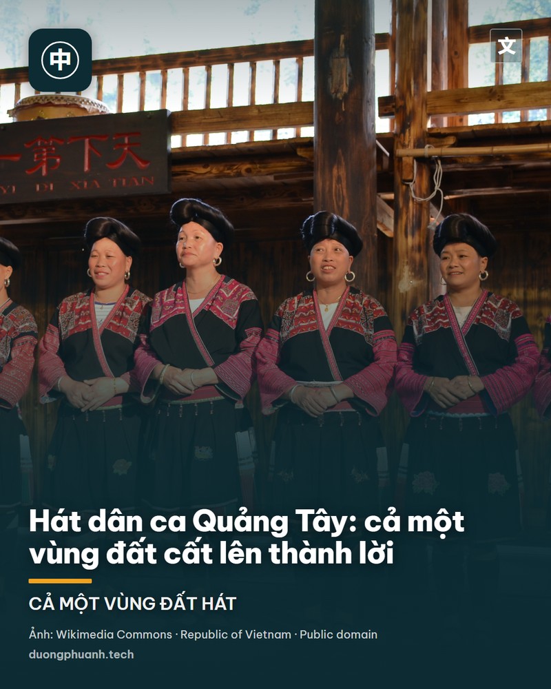 Đêm diễn thực cảnh trên mặt sông: một giàn sân khấu nổi giữa nước, nhóm nghệ sĩ mặc áo đỏ đứng múa hai bên, hai nhân vật chính sáng rực trong làn khói xanh lam, phía sau là màn sương mờ và mặt nước phản chiếu ánh đèn