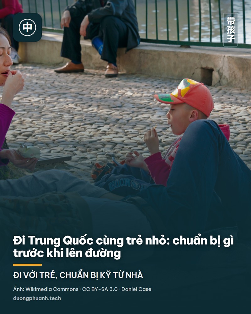 Gia đình Trung Quốc có một em nhỏ ngồi nghỉ và ăn nhẹ dưới gốc cây bên bờ hồ ở công viên Bắc Hải, Bắc Kinh