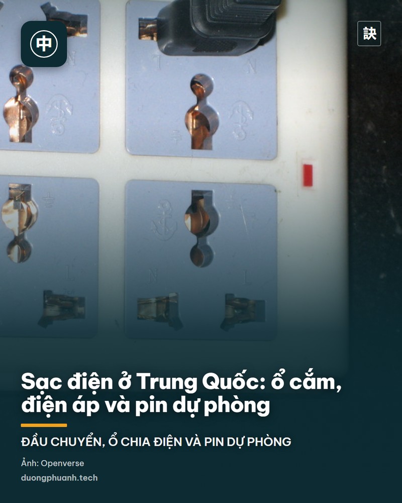 Ổ cắm điện gắn trên tường gỗ ở Trung Quốc với một đầu chuyển du lịch màu trắng đang cắm vào, dây sạc buông xuống nối với thiết bị nhỏ